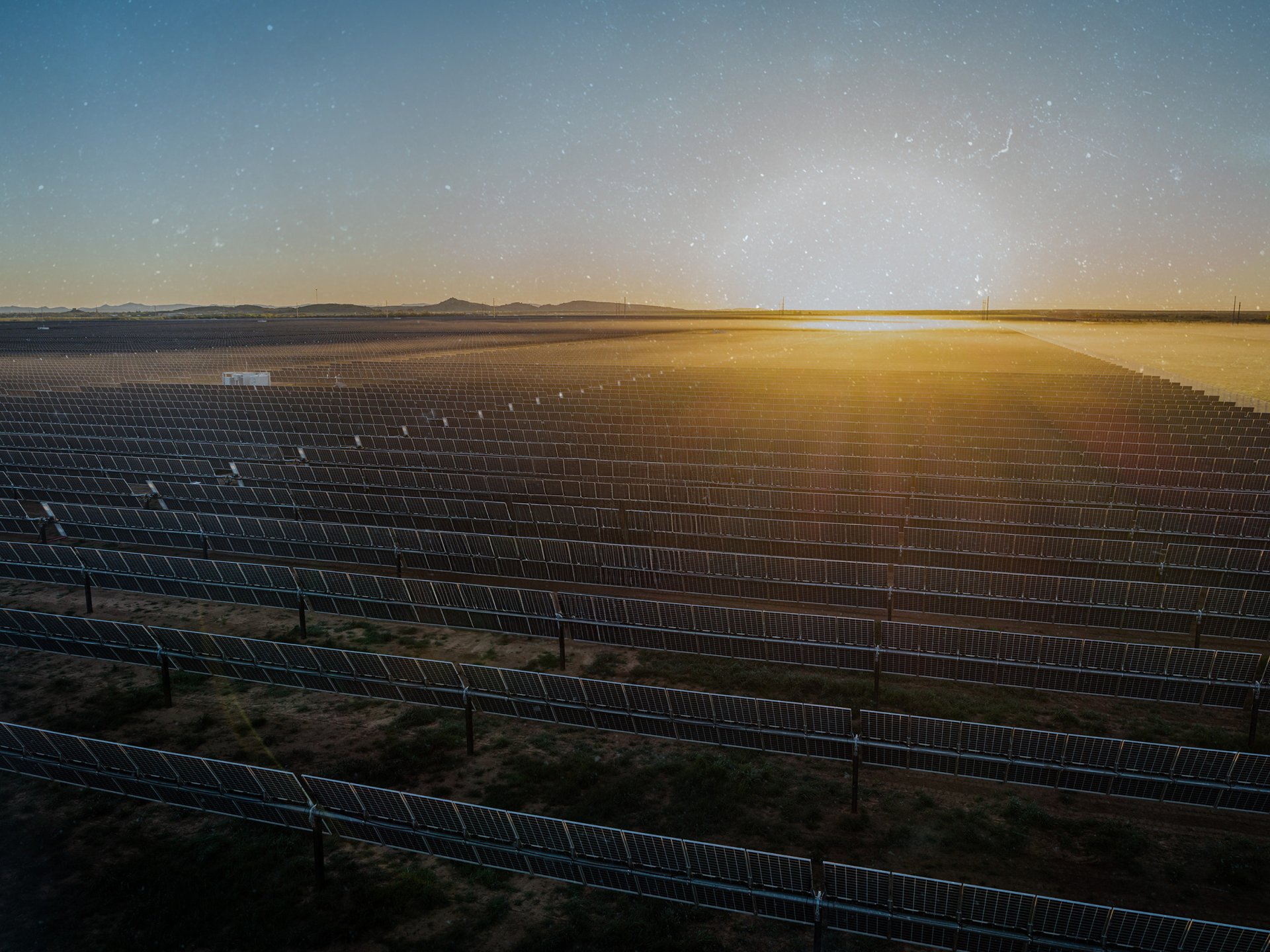 Overhead image of solar farm with sunset in background