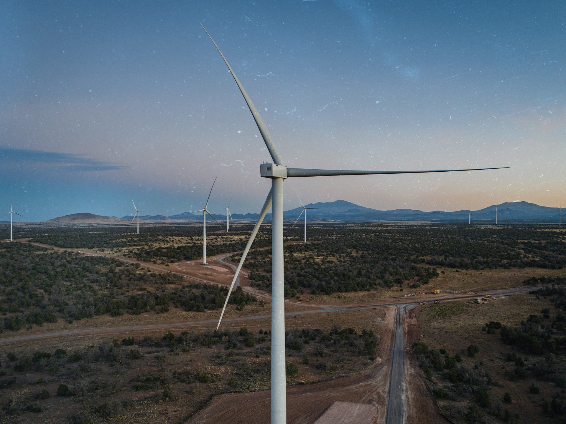 Multiple wind turbines on a high desert plain with grit overlay