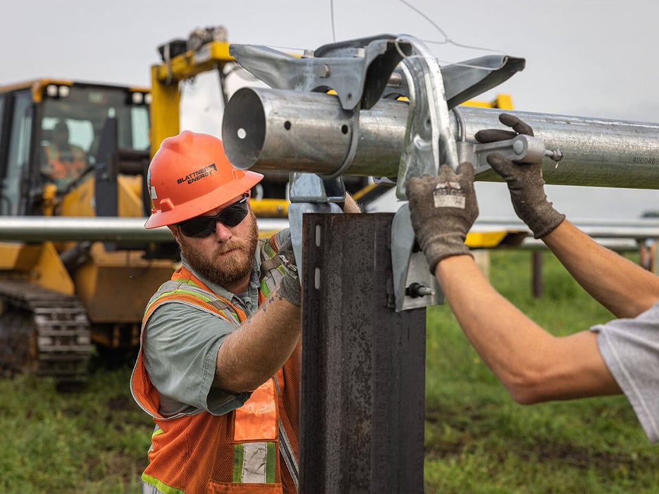 Field team installing solar array infrastructure