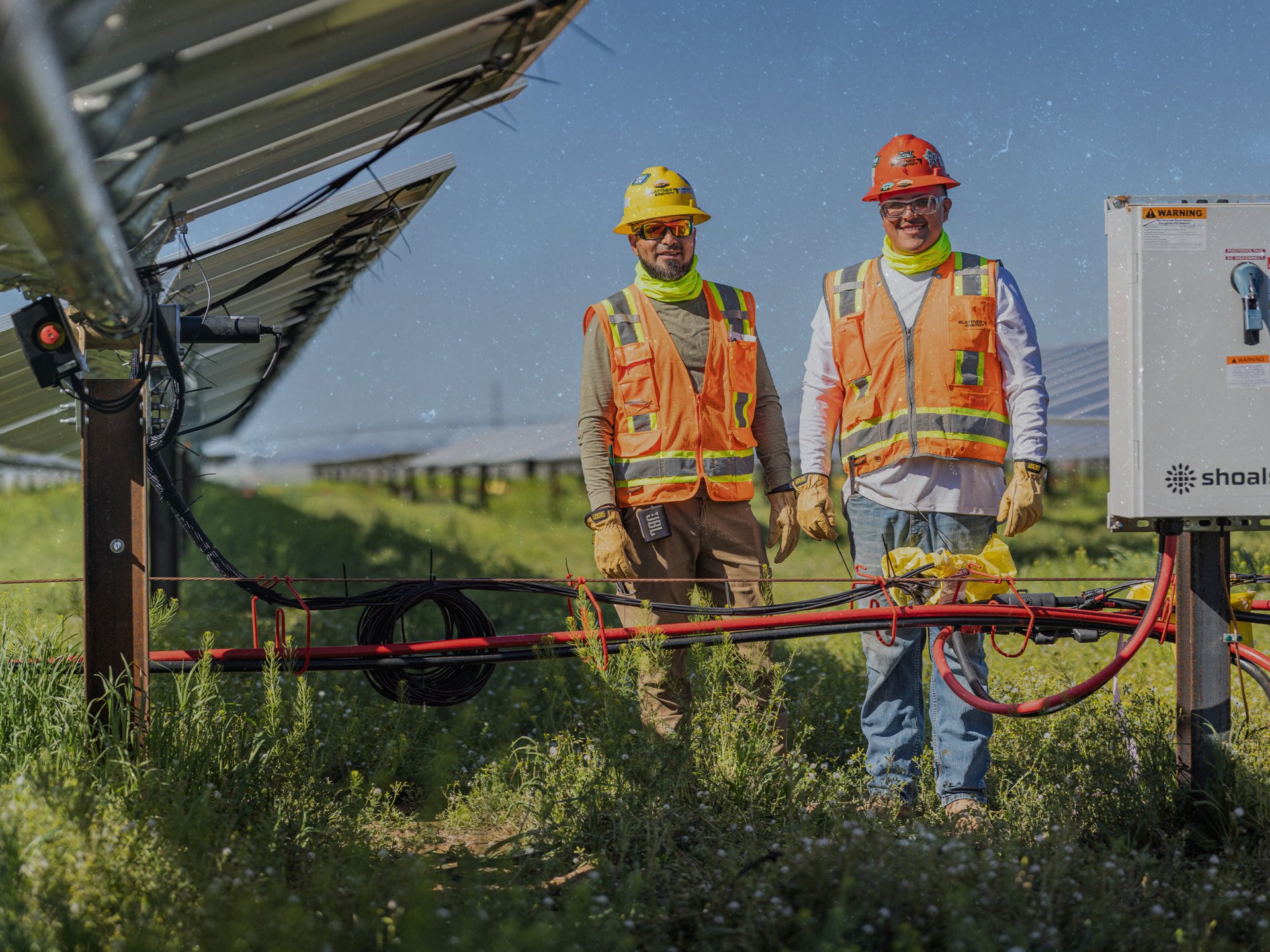 Two male field employees on a solar array