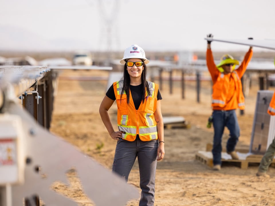 female field team leader on a solar project with a white hard hat