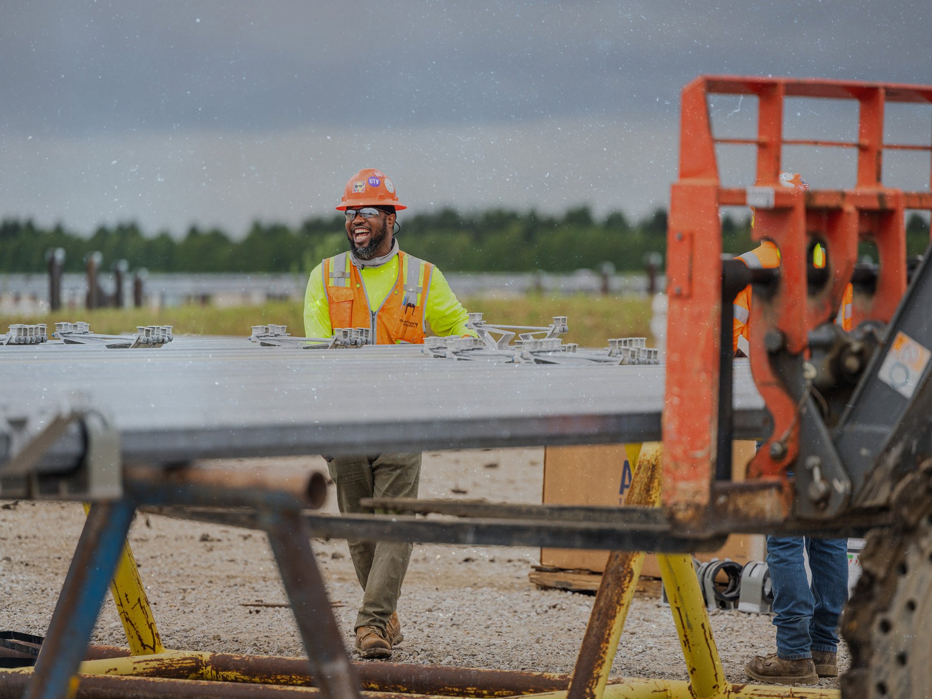 close up of African American male solar worker smiling while working on tubing