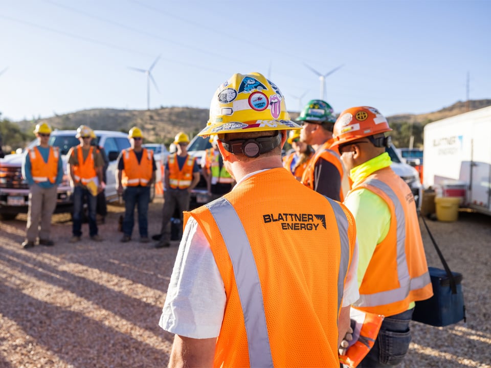 small group of wind turbine project employees at an early morning all hands meeting