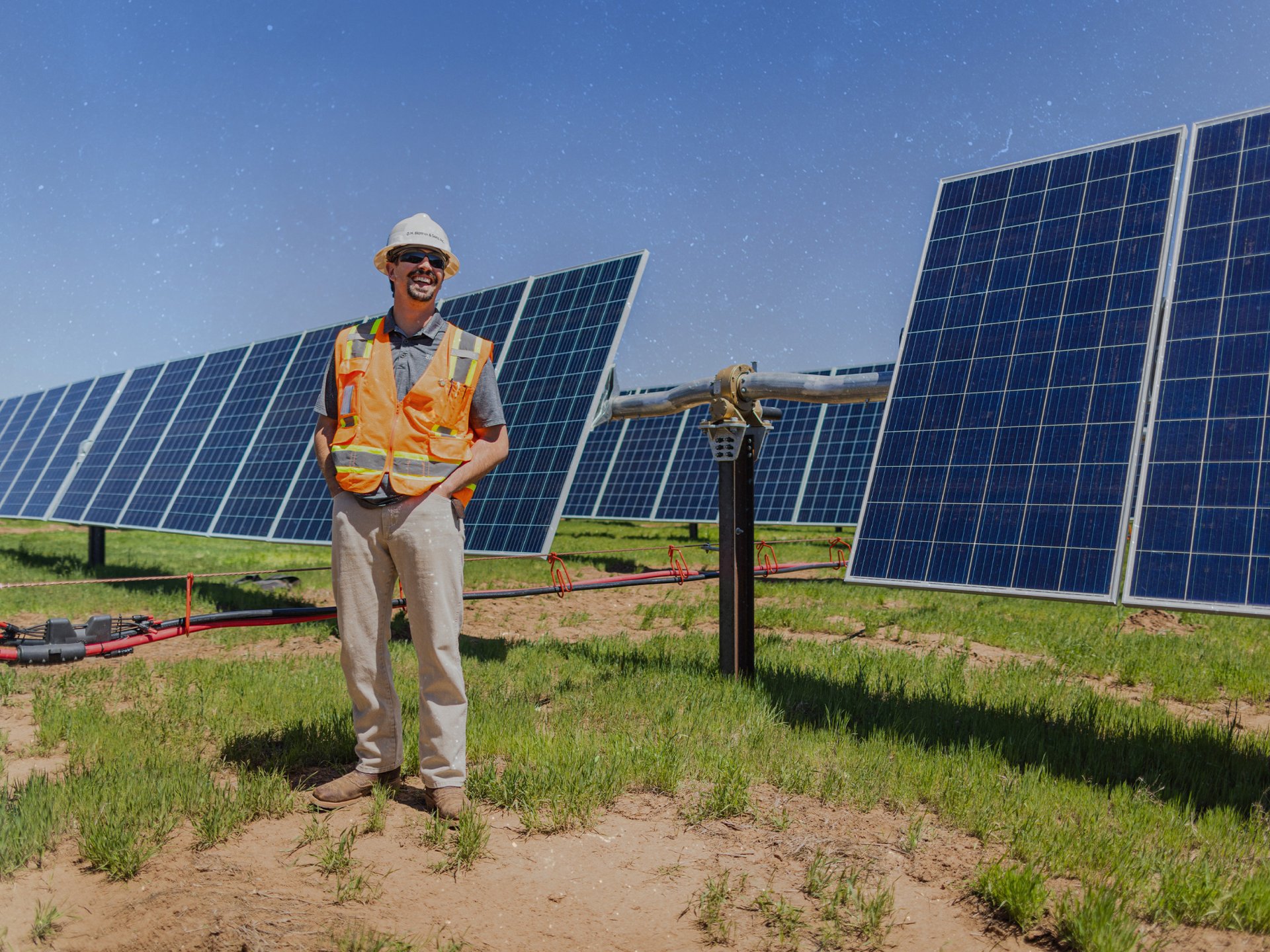 Field worker standing with solar panels behind him